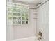 Tiled shower with glass block window and a rainfall shower head, creating a spa-like experience at 5702 Ainsworth W Ct, Tampa, FL 33647