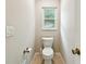 A cozy half-bath featuring toilet and small window at 5702 Ainsworth W Ct, Tampa, FL 33647