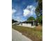 View of single story home, with lush lawn, mature trees, and a screened in porch at 6099 107Th N Ave, Pinellas Park, FL 33782