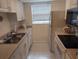 Efficient kitchen featuring white cabinets, modern appliances, and a window that provides natural light to the work space at 650 Pinellas Point S Dr # 101, St Petersburg, FL 33705