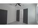 This bedroom features a ceiling fan, window, and gray doors at 7013 N 15Th St, Tampa, FL 33610