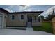 Tan house featuring stairs leading up to the front porch with a black ceiling fan at 7013 N 15Th St, Tampa, FL 33610