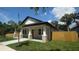 Beautiful single-story home with a covered porch, framed by mature landscaping and a modern wood fence at 7013 N 15Th St, Tampa, FL 33610