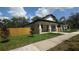 Charming single-story home with a manicured lawn, wood fence and young trees at 7013 N 15Th St, Tampa, FL 33610
