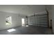 Interior view of detached two car garage, showing door, window, and metal garage door at 7013 N 15Th St, Tampa, FL 33610