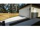View of detached two car garage with white door, adjacent side yard, and fenced backyard at 7013 N 15Th St, Tampa, FL 33610