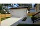 Detached two car garage with concrete driveway, fresh grass, and a sidewalk at 7013 N 15Th St, Tampa, FL 33610