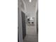 The hallway leads to a kitchen with white cabinets and pendant lights at 7013 N 15Th St, Tampa, FL 33610