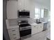 Bright kitchen featuring white cabinets, quartz countertops, and stainless steel appliances at 7013 N 15Th St, Tampa, FL 33610