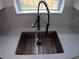 Close-up of the kitchen sink featuring a modern black faucet and light speckled countertop at 7013 N 15Th St, Tampa, FL 33610