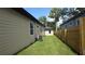 Side yard featuring a privacy fence, air conditioning unit, and green grass at 7013 N 15Th St, Tampa, FL 33610