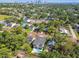 Stunning aerial view of the property featuring a modern home with a pool surrounded by lush greenery and cityscape in the background at 715 W Peninsular St, Tampa, FL 33603