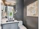 Stylish half-bathroom with dark gray walls, modern fixtures, and decorative artwork at 715 W Peninsular St, Tampa, FL 33603