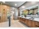 Modern bathroom with dual vanity, wood cabinets, large illuminated mirror, and glass-enclosed shower at 715 W Peninsular St, Tampa, FL 33603