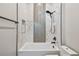 Modern tub/shower with white marble-style tiles, a matte black shower head, and a built-in wall niche at 715 W Peninsular St, Tampa, FL 33603