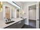 Stylish bathroom boasting dual sinks with quartz countertops, undermount sinks, and gold modern light fixtures at 715 W Peninsular St, Tampa, FL 33603