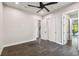 Sleek bedroom featuring gray tile floors, white walls, a modern ceiling fan, and access to a balcony at 715 W Peninsular St, Tampa, FL 33603