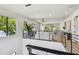Open-concept living area showcasing a modern sofa, bar area, hardwood floors, and multiple windows with treetop views at 715 W Peninsular St, Tampa, FL 33603