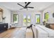 Bright main bedroom featuring hardwood floors, a modern ceiling fan, and ample natural light at 715 W Peninsular St, Tampa, FL 33603