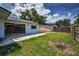 A view of the backyard with a concrete patio, lush grass, and privacy fencing, ideal for relaxing outdoors at 843 Greenfield Dr, Palm Harbor, FL 34684