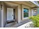 Inviting front porch featuring a white door and a large window with a glimpse of the neighborhood at 843 Greenfield Dr, Palm Harbor, FL 34684