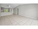 Open-concept living room with tile floors, neutral walls, and a view into the kitchen area at 843 Greenfield Dr, Palm Harbor, FL 34684
