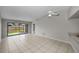 Spacious living room featuring tile floors, a ceiling fan, and access to the backyard through sliding doors at 843 Greenfield Dr, Palm Harbor, FL 34684