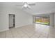 Bright main bedroom with tile flooring, ceiling fan and sliding door access to the fenced backyard at 843 Greenfield Dr, Palm Harbor, FL 34684