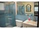 Bathroom featuring blue tile, a glass shower door, and a white vanity with a sink at 9639 Mainlands E Blvd, Pinellas Park, FL 33782