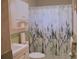 Bathroom showcasing a sea themed shower curtain, toilet, sink and green tile at 9639 Mainlands E Blvd, Pinellas Park, FL 33782