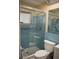 Bathroom featuring blue tiled walls, a glass-enclosed shower, and modern fixtures at 9639 Mainlands E Blvd, Pinellas Park, FL 33782