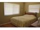 This cozy bedroom features two windows, hardwood floors, and a comfortable bed at 9639 Mainlands E Blvd, Pinellas Park, FL 33782