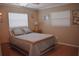 Cozy bedroom with a comfortable bed, neutral tones, and natural light from two windows at 9639 Mainlands E Blvd, Pinellas Park, FL 33782