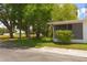 This home has an enclosed porch surrounded by lush green landscaping and mature trees at 9639 Mainlands E Blvd, Pinellas Park, FL 33782