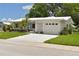 Charming single-story home with a white tile roof, bright shutters, an attached garage, and well-manicured landscaping at 9639 Mainlands E Blvd, Pinellas Park, FL 33782