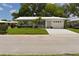 Bright single-story home with a well-manicured lawn, palm trees, and a white tile roof at 9639 Mainlands E Blvd, Pinellas Park, FL 33782