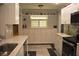 Bright kitchen featuring white cabinetry, ample storage, and a clean, modern design with black and white tile floors at 9639 Mainlands E Blvd, Pinellas Park, FL 33782