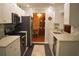 Well-lit kitchen featuring stainless steel appliances, sleek white cabinetry, marble countertops and black and white tiled floors at 9639 Mainlands E Blvd, Pinellas Park, FL 33782