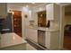 Bright kitchen with white cabinets, marble countertops, stainless steel dishwasher and pass through to living area at 9639 Mainlands E Blvd, Pinellas Park, FL 33782