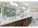 Modern bathroom with double sinks, white countertops, dark cabinets, and large mirror and tiled shower at 4222 Hartwood Ln # 1202, Tampa, FL 33618