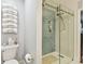 Bathroom featuring a modern glass enclosed shower and gray tiled walls, complemented by a toilet with stacked towels at 4222 Hartwood Ln # 1202, Tampa, FL 33618