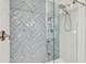 Bathroom features gray tiled walls, a glass shower enclosure, and a built-in shower niche at 4222 Hartwood Ln # 1202, Tampa, FL 33618