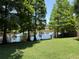 Expansive backyard overlooking a tranquil pond with lush trees and a well-maintained lawn at 1010 Elm Grove Ln, Valrico, FL 33596