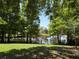Scenic backyard view features a serene pond bordered by mature trees and a classic black chain link fence at 1010 Elm Grove Ln, Valrico, FL 33596