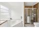 Bright bathroom featuring a garden tub and tiled shower at 1010 Elm Grove Ln, Valrico, FL 33596