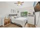 Bright bedroom with a gray upholstered headboard and large window with backyard views at 1010 Elm Grove Ln, Valrico, FL 33596