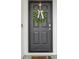 Close-up of a stylish black front door adorned with a wreath at 1010 Elm Grove Ln, Valrico, FL 33596