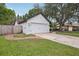 Side view of a spacious two-car garage with white doors and exterior lighting at 1010 Elm Grove Ln, Valrico, FL 33596