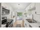 Clean, bright kitchen with stainless steel appliances, white cabinets, and an open view of the backyard at 1010 Elm Grove Ln, Valrico, FL 33596