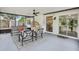 Inviting screened porch with modern seating, ceiling fan, and serene backyard views at 1010 Elm Grove Ln, Valrico, FL 33596